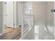 Hallway with hardwood floors and white railings that brightens the entrance to this home at 202 Water Oak Dr, Pineville, NC 28134