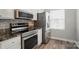 Bright kitchen with stainless steel appliances, stone countertops, and wood-look flooring at 202 Water Oak Dr, Pineville, NC 28134