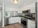 Updated kitchen with granite counters, stainless appliances, and wood flooring at 202 Water Oak Dr, Pineville, NC 28134