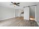 Open living room featuring wood floors, a ceiling fan and a stylish sliding barn door at 202 Water Oak Dr, Pineville, NC 28134