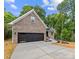 Stunning brick home with a black garage door, landscaped walkway, and beautifully paved driveway at 2108 Lakeview Cir, Matthews, NC 28105
