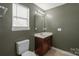 Bathroom with dark green walls, modern vanity, and window with blind at 306 Fesperman Cir, Troutman, NC 28166