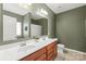 Well-lit bathroom featuring a double vanity with modern fixtures and a large mirror at 306 Fesperman Cir, Troutman, NC 28166