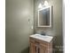 Charming powder room with a modern vanity, a stylish mirror, and modern faucet at 306 Fesperman Cir, Troutman, NC 28166