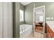 Bathroom featuring a soaking tub and view into the bedroom with a door at 306 Fesperman Cir, Troutman, NC 28166