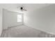 Bedroom features neutral carpet, ceiling fan, and a window with natural light at 306 Fesperman Cir, Troutman, NC 28166