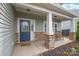 Cozy front porch with rocking chairs and stone-clad columns, leading to a blue front door at 306 Fesperman Cir, Troutman, NC 28166