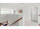 Bright hallway features neutral carpeting, white walls, wood railing, and natural light at 306 Fesperman Cir, Troutman, NC 28166