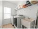 Efficient laundry room with modern washer and dryer, utility sink, and plenty of storage space at 306 Fesperman Cir, Troutman, NC 28166