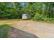 Backyard featuring storage building, gravel area, and green trees at 3442 Cedar Circle Rd, Lancaster, SC 29720