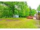 Expansive backyard with mature trees, green lawn, and a storage shed at 3491 Mcconnells Hwy, Rock Hill, SC 29732