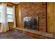A close-up of a classic brick fireplace featuring a metal grate, accented by natural light at 3491 Mcconnells Hwy, Rock Hill, SC 29732