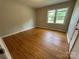 Inviting bedroom with hardwood floors, neutral walls, and a window offering natural light at 5008 Delivau Dr, Charlotte, NC 28215