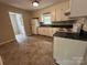 Well-lit kitchen features white cabinets, black counters, white appliances, and view into adjacent room at 5008 Delivau Dr, Charlotte, NC 28215