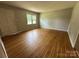 Bright living room featuring gleaming hardwood floors, neutral walls, and a window offering plenty of natural light at 5008 Delivau Dr, Charlotte, NC 28215