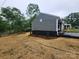 The back of this home features updated paint, a small deck, and tasteful landscaping at 501 N Hawthorne St, Mount Holly, NC 28120