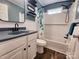 This renovated bathroom has a shower, vanity, black faucet, and blue floral shower curtain at 501 N Hawthorne St, Mount Holly, NC 28120