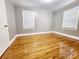 This bedroom features a hardwood floor, light fixture, and white trim at 501 N Hawthorne St, Mount Holly, NC 28120