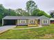 The front of the home boasts new gravel driveway, a carport, a covered front porch, and updated exterior paint at 501 N Hawthorne St, Mount Holly, NC 28120