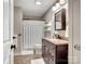Well-lit bathroom with a vanity, granite countertop, and shower, creating a functional and inviting space at 6758 Zion Church Rd, Concord, NC 28025