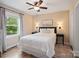 Inviting bedroom featuring a comfortable bed, a ceiling fan, and a large window offering abundant natural light at 6758 Zion Church Rd, Concord, NC 28025