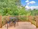 Outdoor deck with seating area, surrounded by lush greenery and blue skies, offers a serene space to unwind at 6758 Zion Church Rd, Concord, NC 28025