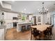 Open kitchen featuring white cabinets, stainless steel appliances, island, and adjacent dining area at 6758 Zion Church Rd, Concord, NC 28025