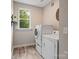 Functional laundry room with a modern washer and dryer set, complemented by natural light from a window at 6758 Zion Church Rd, Concord, NC 28025