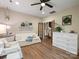 Inviting living room with hardwood floors, white furniture, and a large dresser adding storage space at 6758 Zion Church Rd, Concord, NC 28025