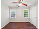 Bedroom with hardwood floors, a ceiling fan with light, and two windows for natural light at 6807 Woodfield Dr, Charlotte, NC 28215