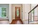 Inviting entryway featuring a decorative wood door, hardwood floors, and staircase access at 6807 Woodfield Dr, Charlotte, NC 28215