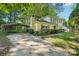 View of the house with a long driveway and a metal carport on the side at 6807 Woodfield Dr, Charlotte, NC 28215