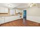 Updated kitchen featuring white cabinets, laminate countertop, and hardwood flooring at 6807 Woodfield Dr, Charlotte, NC 28215
