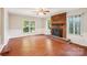 Bright living room featuring a cozy fireplace, hardwood floors, and large windows at 6807 Woodfield Dr, Charlotte, NC 28215
