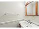 Powder room with hardwood vanity, classic sink and framed mirror at 6807 Woodfield Dr, Charlotte, NC 28215