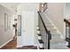 Foyer featuring a carpeted staircase with decorative black iron railing and hardwood floors at 6807 Woodfield Dr, Charlotte, NC 28215