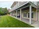 An outdoor patio with columns and fans overlooking a green lawn with outdoor furniture at 7471 Barfield Ln, Denver, NC 28037