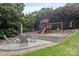 Outdoor fire pit area with play structure and surrounding green landscape, perfect for Gathering enjoyment at 7471 Barfield Ln, Denver, NC 28037