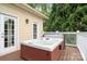 Outdoor jacuzzi featuring a wooden deck, built-in hot tub, white railings, and outdoor lighting at 7471 Barfield Ln, Denver, NC 28037