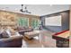 Spacious basement area features a stone fireplace, large screen, shuffleboard and comfortable leather furnishings at 7471 Barfield Ln, Denver, NC 28037