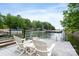 A serene lake view from the dock featuring two chairs on a sunny day at 7471 Barfield Ln, Denver, NC 28037