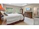 A bright main bedroom is well-lit with an ensuite bathroom, closet, and large dresser at 7471 Barfield Ln, Denver, NC 28037
