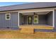 Inviting back porch with wood steps, ceiling fan, and a stylish entry door at 750 Whites Farm Rd, Statesville, NC 28625