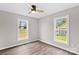 Bedroom with two windows, wood-look flooring, neutral walls, and a ceiling fan at 750 Whites Farm Rd, Statesville, NC 28625