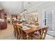 Open-concept dining area showcases a wooden table, seating for eight, and an adjacent kitchen and living room at 8200 Sunset Hill Rd, Waxhaw, NC 28173