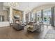 Open-plan living room with stone fireplace, large windows and adjacent pool views at 8200 Sunset Hill Rd, Waxhaw, NC 28173