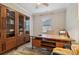Well lit home office with light wood floors, display cabinet, an office desk and an area rug at 8200 Sunset Hill Rd, Waxhaw, NC 28173