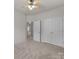 Spacious carpeted bedroom with ceiling fan and a large closet with doors for storage at 8313 Carob Tree Ln, Charlotte, NC 28215