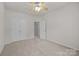 Cozy bedroom with carpeted floors, ceiling fan, a large closet and a door to another bedroom at 8313 Carob Tree Ln, Charlotte, NC 28215