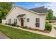 View of cream-colored home with brown door and well-maintained landscaping at 8313 Carob Tree Ln, Charlotte, NC 28215